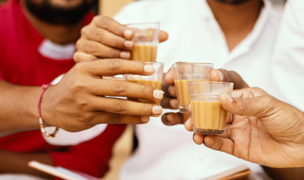 Close up of hands cheers Tea glasses - concept showing group of friends enjoying morning Tea by cheering at Hotel